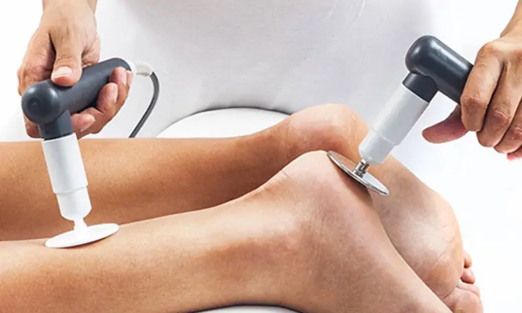 Winback Tecar therapy applied to a patient's knee with two handpieces